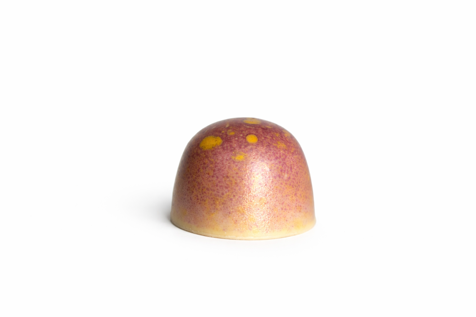 White Granadilla chocolate bonbon with purple and yellow speckled finish